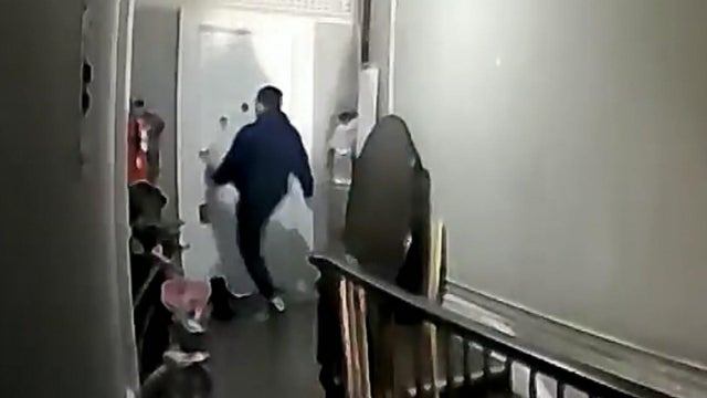 A photo of a man kicking in an apartment door. 