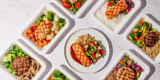 Overhead view of eight different single serving meals showcasing a mix of protein, vegetables and rice 