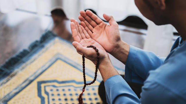 Muslim Man With Open Palm Praying at Home During Month of Ramadan 