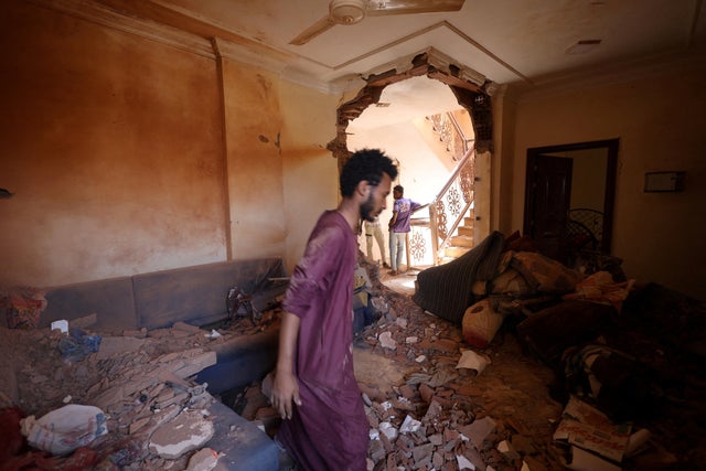 A man looks at the damage inside a house during clashes between the paramilitary Rapid Support Forces and the army in Khartoum 