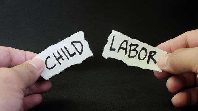 Stop and fight child labor concept. Human hand tearing a piece paper with written word child labor. Children rights protection. 