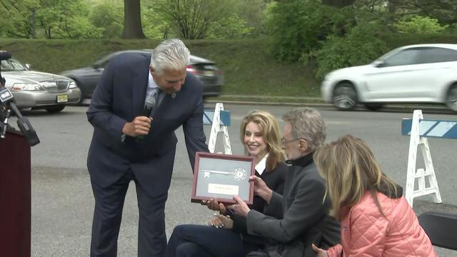 A Newark official hands Frankie Valli a framed key. 