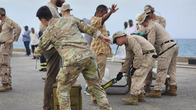 American nationals are searched by the U.S. soldiers before boarding a ship in Port Sudan, Sunday, April 30, 2023. 