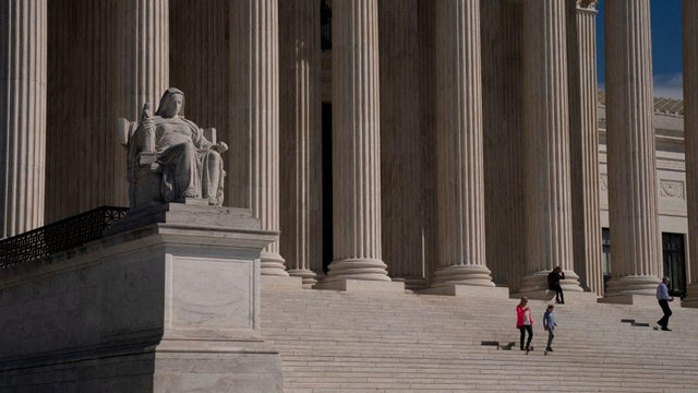 Visitors walk down the steps of the Supreme Court in Washington, D.C., on March 22, 2023. 