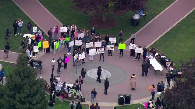 An aerial video of a few dozen students holding signs standing on the Seton Hall University campus. 
