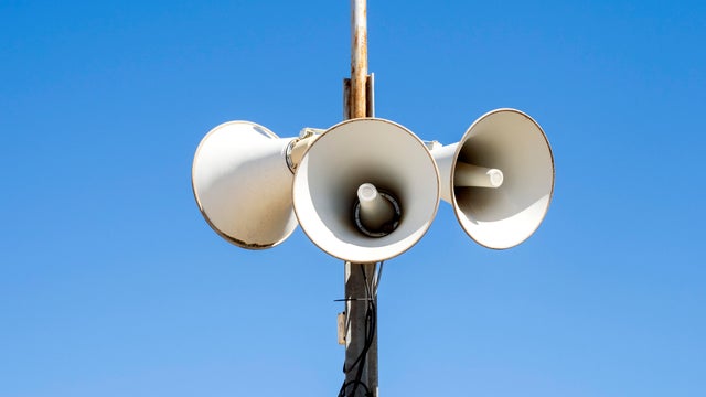 Civil defense siren on the street against a blue sky. 