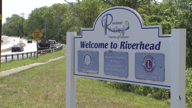A "welcome to Riverhead" sign on the side of a road. 