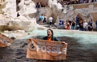 Climate activist holds banner in Trevi Fountain, Rome 