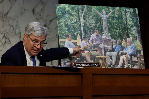 Senate Judiciary Committee member Sen. Sheldon Whitehouse displays a copy of a painting featuring Supreme Court Associate Justice Clarence Thomas alongside other conservative leaders during a hearing on Supreme Court ethics reform in the Hart Senate Offic