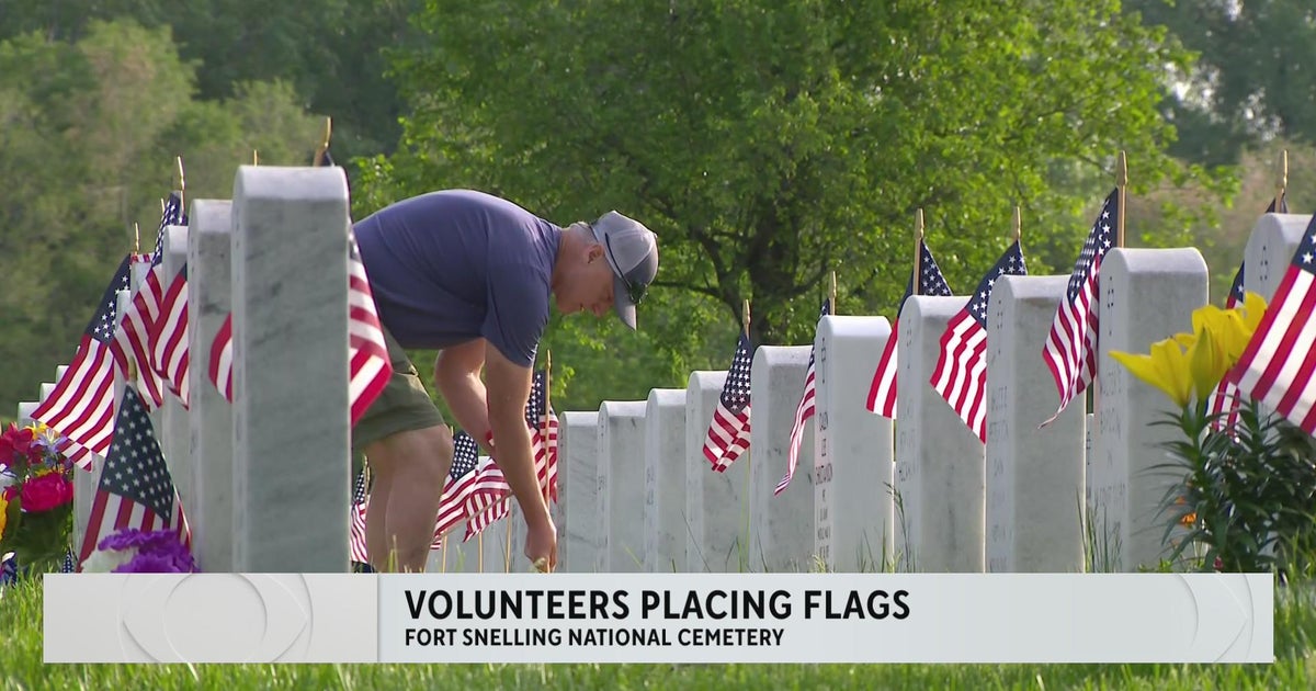 Volunteers place flags at Ft. Snelling gravestones for Memorial Day