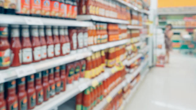 ketchup sauce seasoning bottles products in supermarket shelves blurred background 