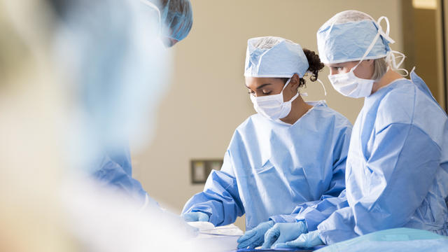 Surgeons preparing for procedure in operating room 