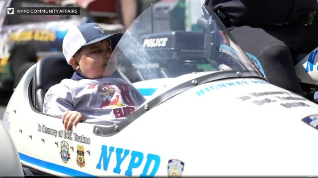 An 8-year-old boy sits in the side car of an NYPD motorcycle. 
