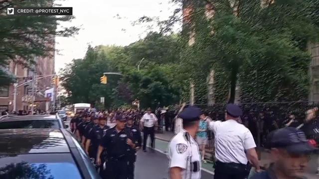 Video shows a large number of police officers walking behind marchers. 