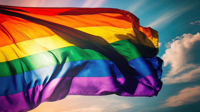 gay pride rainbow flag fluttering backlit in bright sunny sky. AI-Generated 