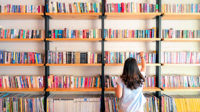 Asian women are picking up books on the bookshelf. To prepare to back to school 