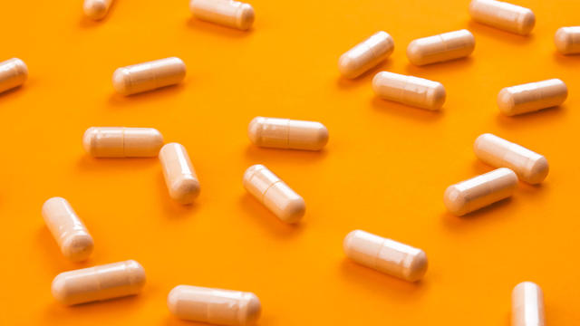 Beige pills on a bright orange background 
