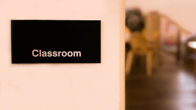 classroom sign & partial defocused view of classroom from outside classroom door 