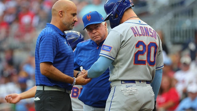 Pete Alonso #20 of the New York Mets converses with manager Buck Showalter #11 and the trainer after he is hit by pitch in the first inning against Charlie Morton #50 of the Atlanta Braves at Truist Park on June 07, 2023 in Atlanta, Georgia. Alonso was pu 