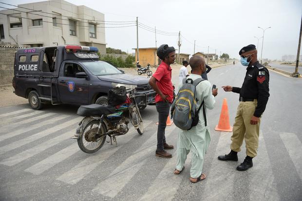Police stop motorcyclists along a closed coastal road in Karachi, Pakistan, June 13, 2023, as Cyclone Biparjoy makes its way across the Arabian Sea toward the coastlines of Pakistan and India. 
