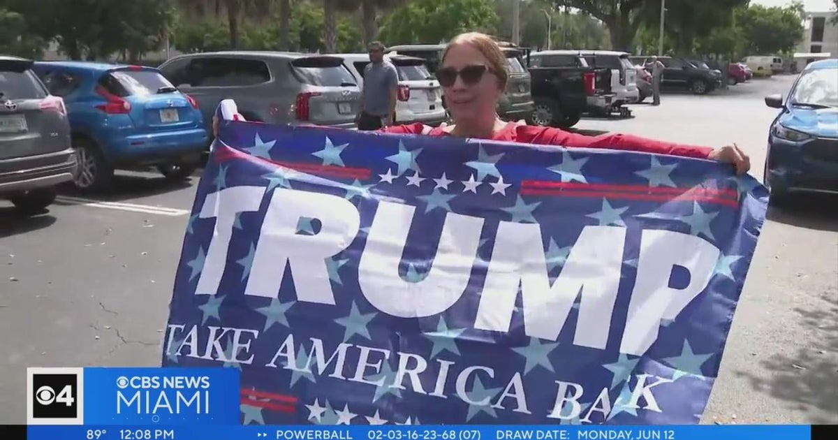 Trump supporters wave flags in entrance of Trump National Doral vacation resort