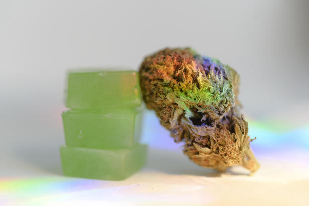 Stack of edible cannabis gummies and cannabis bud 