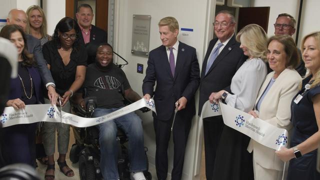Eric LeGrand and several other people attend a ribbon-cutting ceremony at the Eric LeGrand Spinal Cord Injury Patient Care Room 