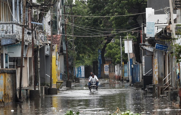 A man rides a motorcycle through a flooded street in Mandvi, India, before the arrival of Cyclone Biparjoy in the western state of Gujarat, June 15, 2023
