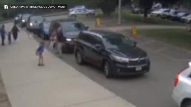 A New Jersey police officer holds a child after pulling her out of the way of an SUV that was backing up. 