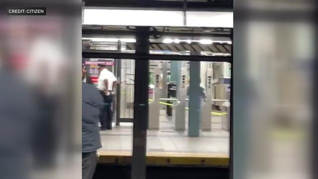 Crime scene tape blocks off turnstiles in a subway station. 