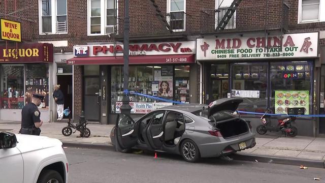 A sedan is crashed into a lamppost on the curb of a sidewalk. 