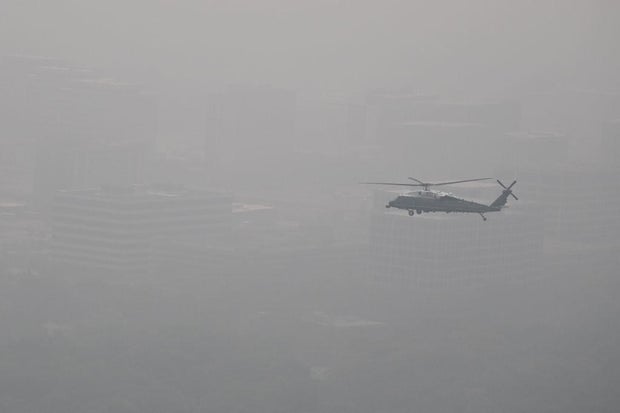 In this aerial view, Marine One carries President Biden over a hazy Chicago on June 28, 2023.