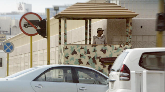 A Saudi security guard monitors movement outside the walls of the US consulate in the Red Sea port city of Jeddah on Dec. 7, 2004. 
