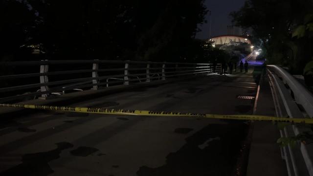 Crime scene tape blocks off a bridge leading to Riverbank State Park. 