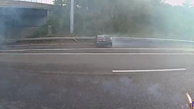 A sedan skids sideways on a highway. 