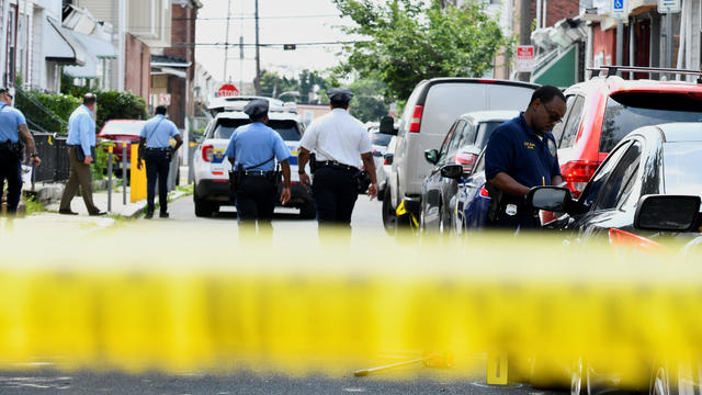 Police officers work at the scene the day after a mass shooting in the Kingsessing section of southwest Philadelphia, Pennsylvania, July 4, 2023. 