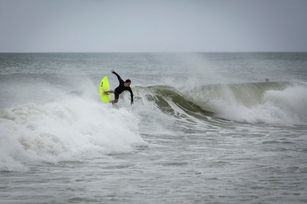 A surfer rides a wave in Deerfield Beach, Florida