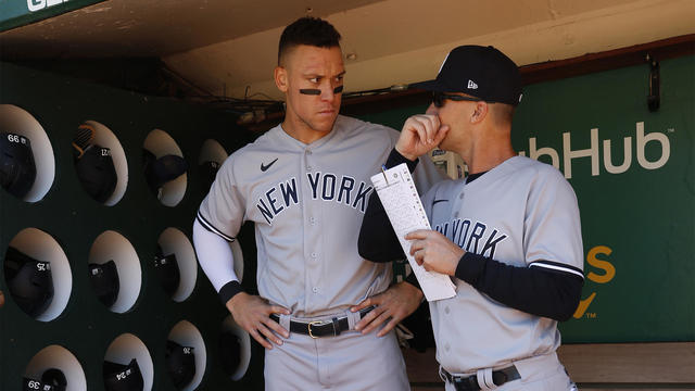 Aaron Judge #99 and Hitting Coach Dillon Lawson #74 of the New York Yankees in the dugout before the game against the Oakland Athletics at RingCentral Coliseum on August 28, 2022 in Oakland, California. 