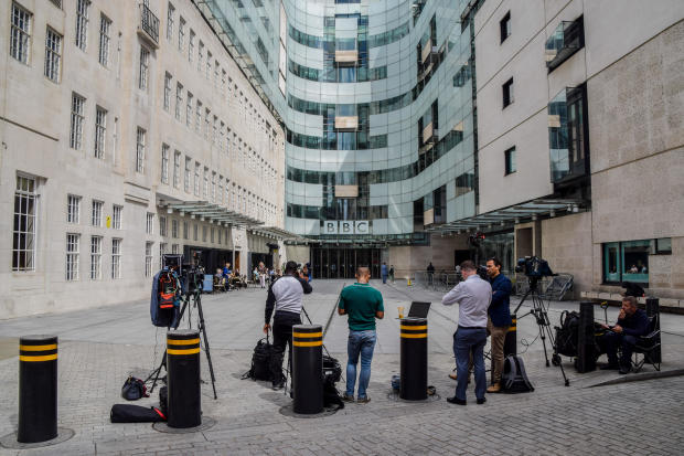 Members of the media gather outside Broadcasting House, the 
