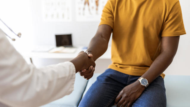 Male patient shaking hands with female therapist 