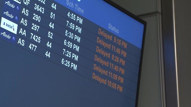 A departures board at Newark Liberty International Airport lists six flights as delayed. 