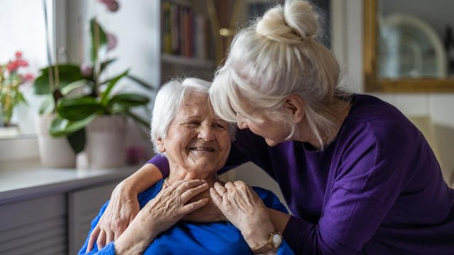 Woman hugging her elderly mother 