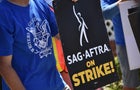 WGA member holding SAG-AFTRA strike sign 