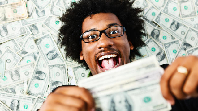 Overjoyed young man surrounded by US dollars 