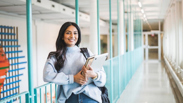 Portrait of young female student in corridor of university 