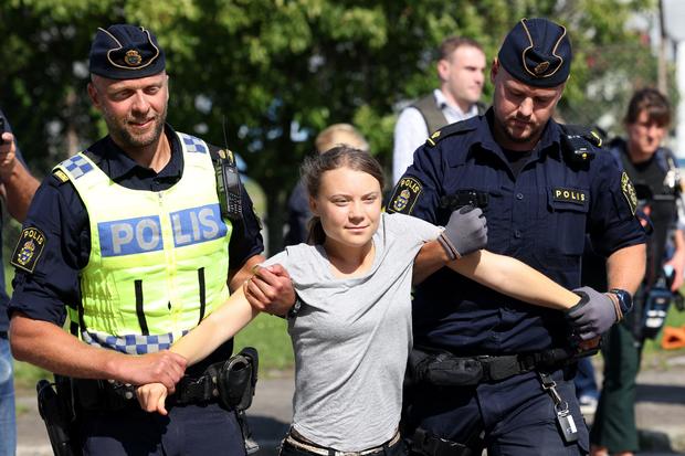 Greta Thunberg is carried away by police officers after she took part in a new climate protest in Malmo, Sweden, on July 24, 2023, shortly after the city's district court convicted and sentenced her to a fine for disobeying police at a rally last month in Malmo. 