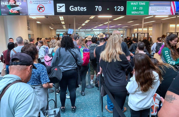 People wait in a TSA screening line at Orlando International Airport three days before Thanksgiving in Orlando, Florida, Nov. 21, 2022.