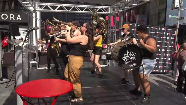 The Brass Queens band performs on stage in Times Square. 