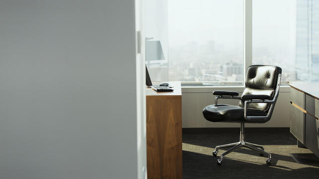 bright corner office space with desk and chairs 