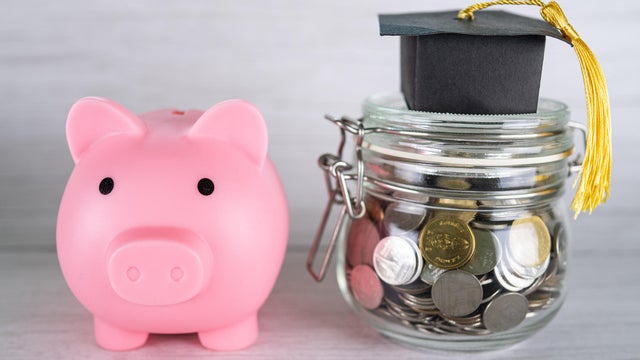 Close-up of coins in jar with piggy bank on table,Romania 